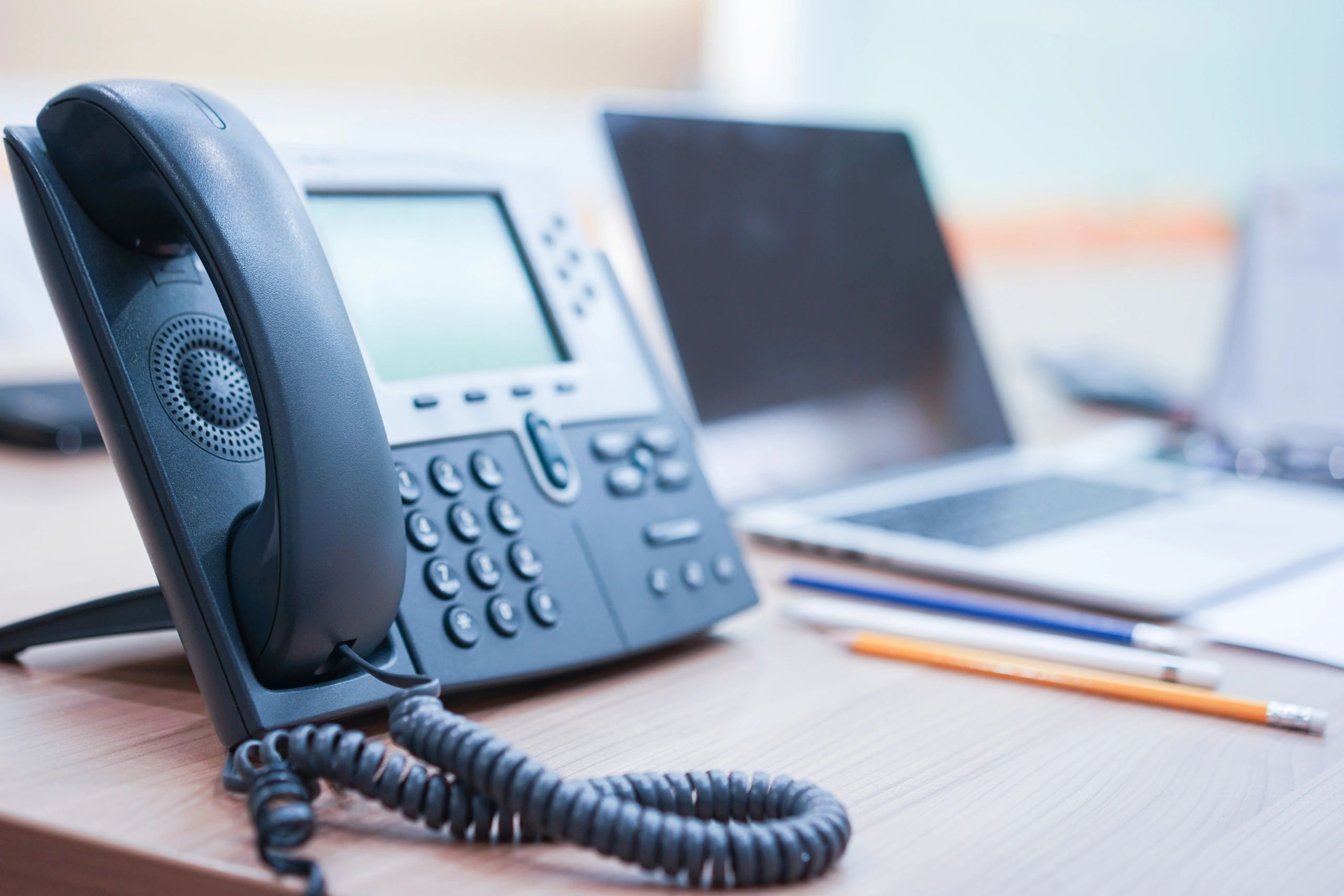 Office desk phones representing VoIP support and call handling